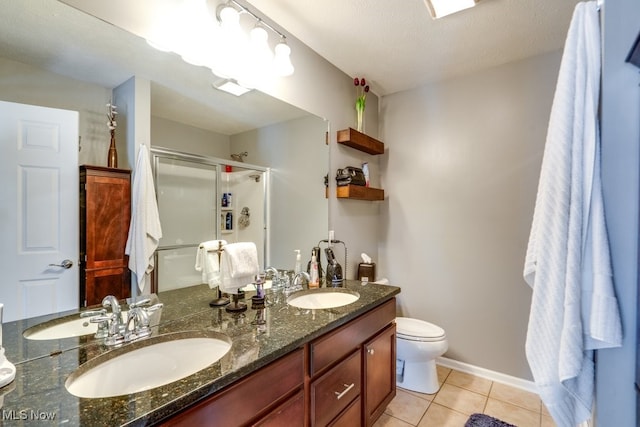 bathroom featuring vanity, a textured ceiling, tile patterned floors, walk in shower, and toilet