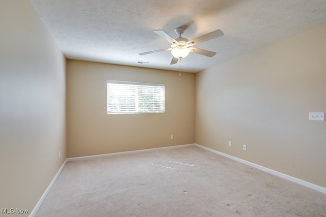 carpeted spare room with ceiling fan and a textured ceiling