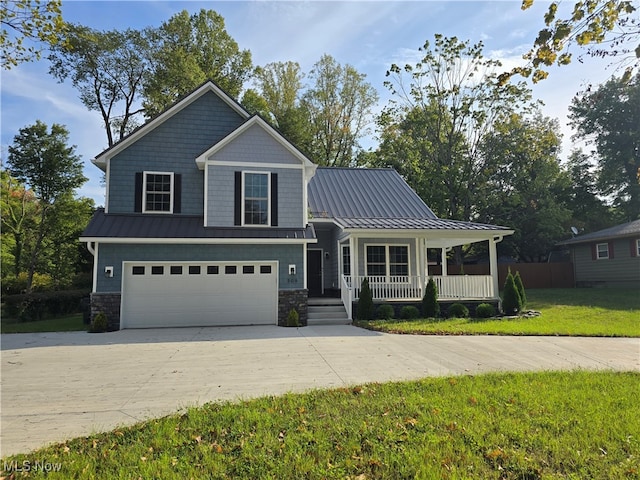 view of front of home featuring a porch, a garage, and a front lawn