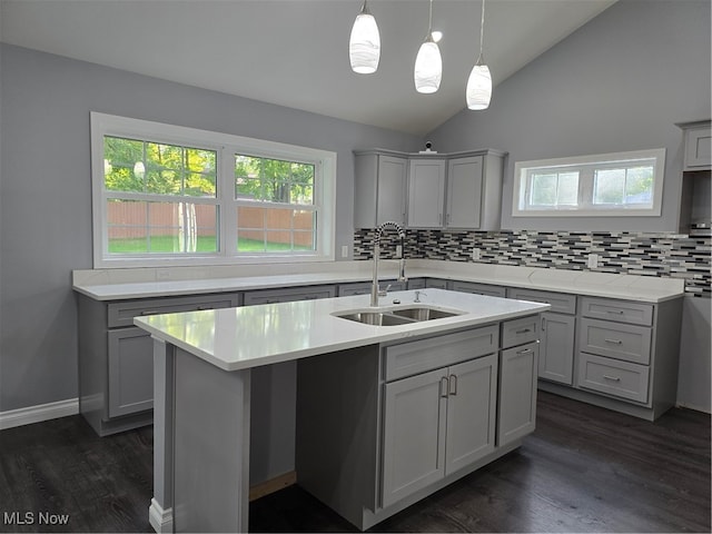 kitchen featuring gray cabinets, dark hardwood / wood-style floors, a kitchen island with sink, sink, and lofted ceiling