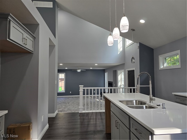 kitchen featuring an island with sink, gray cabinets, sink, and a healthy amount of sunlight