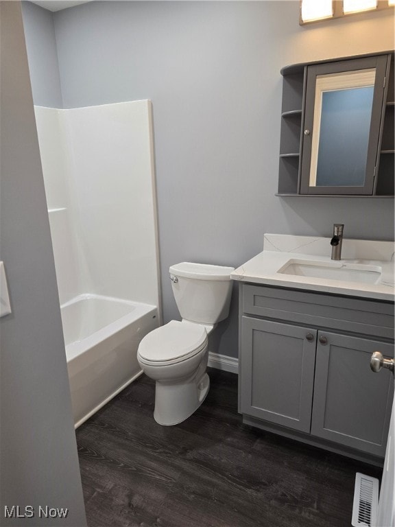 full bathroom with hardwood / wood-style floors, shower / bathtub combination, vanity, and toilet