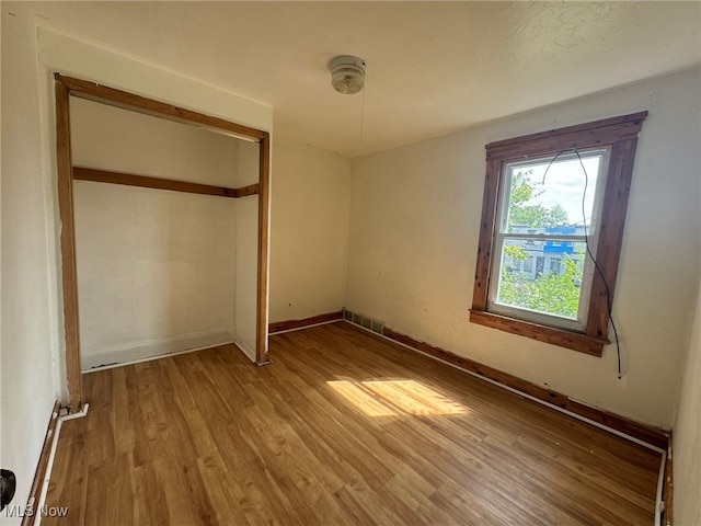 unfurnished bedroom featuring a closet and light hardwood / wood-style floors