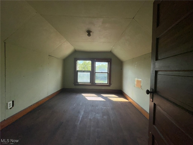 bonus room featuring vaulted ceiling and dark wood-type flooring