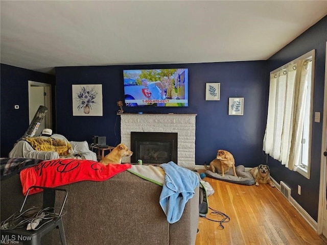 living room with hardwood / wood-style flooring and a fireplace