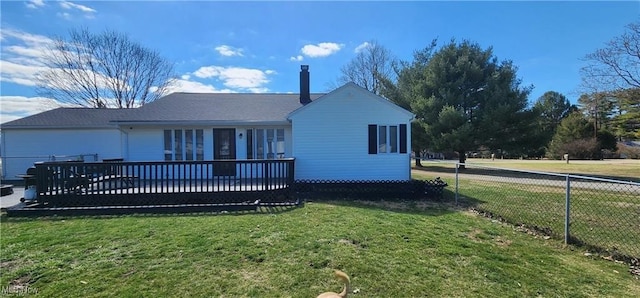 rear view of house with a lawn and a wooden deck