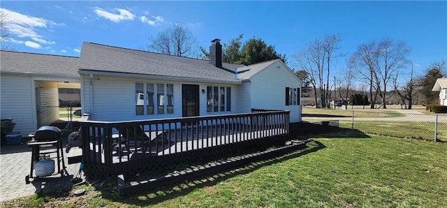 rear view of house featuring a lawn and a deck