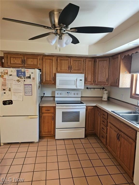 kitchen featuring light tile patterned floors, white appliances, sink, and ceiling fan