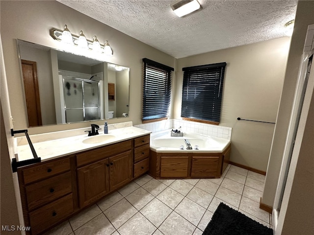 bathroom featuring tile patterned floors, a textured ceiling, vanity, and separate shower and tub