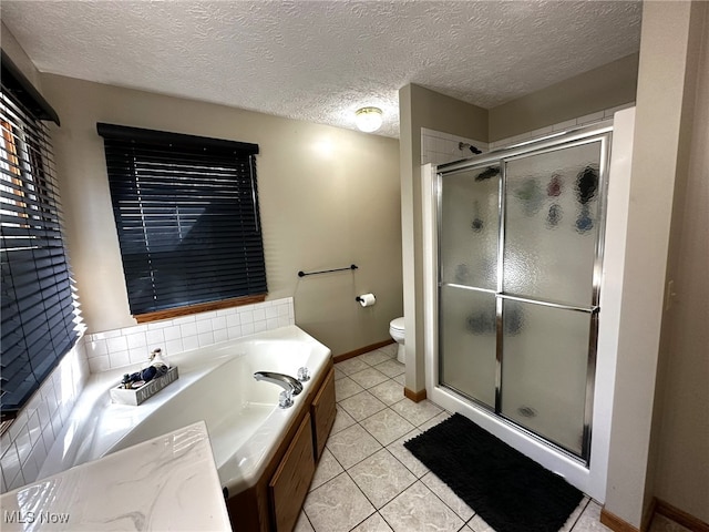 full bathroom featuring vanity, toilet, a textured ceiling, plus walk in shower, and tile patterned flooring