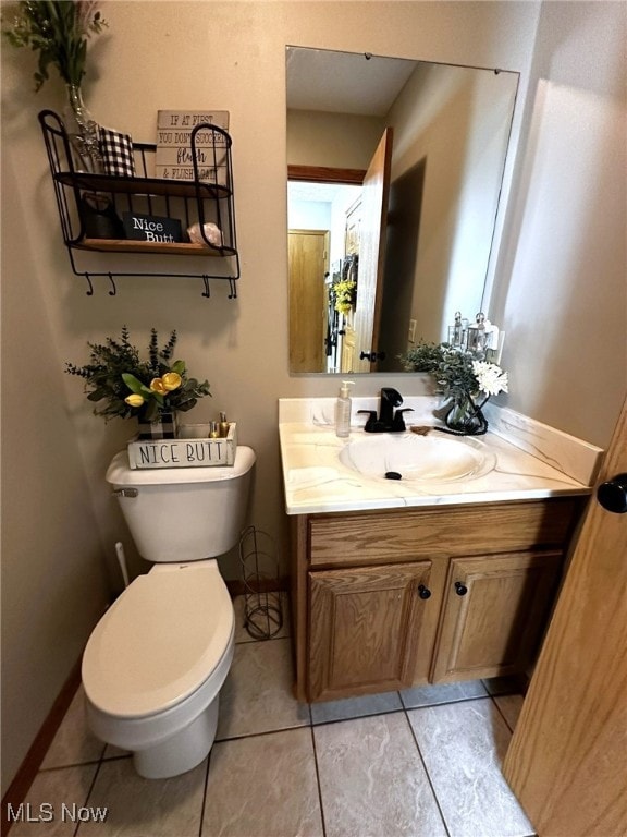 bathroom featuring tile patterned flooring, vanity, and toilet