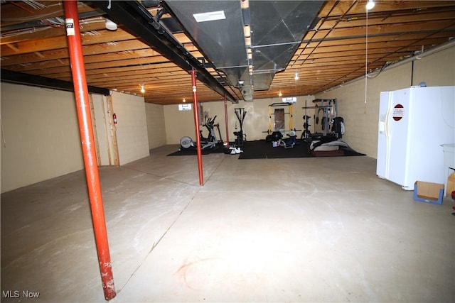 basement with white fridge with ice dispenser