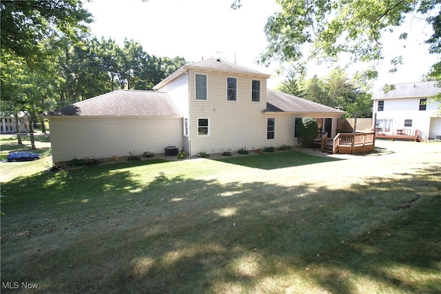 rear view of property featuring a lawn and a wooden deck