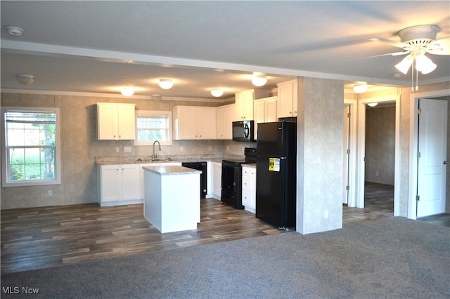 kitchen with black appliances, plenty of natural light, a kitchen island, and dark hardwood / wood-style flooring