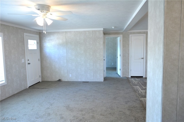 foyer featuring ceiling fan and carpet flooring