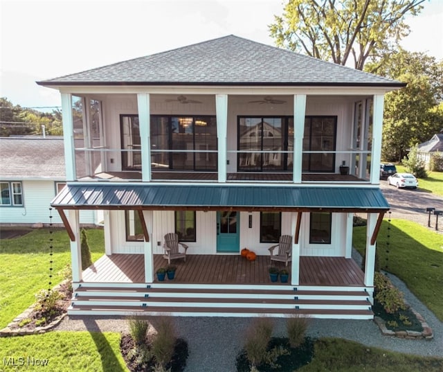 back of house featuring a sunroom and a lawn