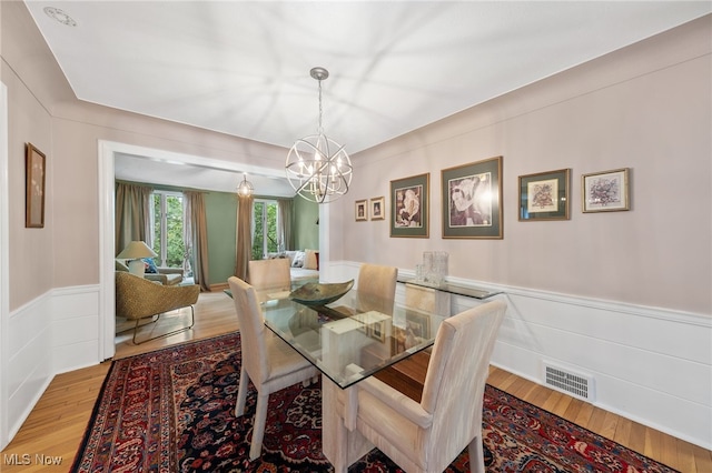 dining room featuring hardwood / wood-style flooring and a chandelier