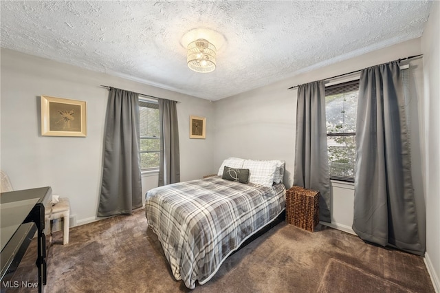 carpeted bedroom featuring multiple windows and a textured ceiling