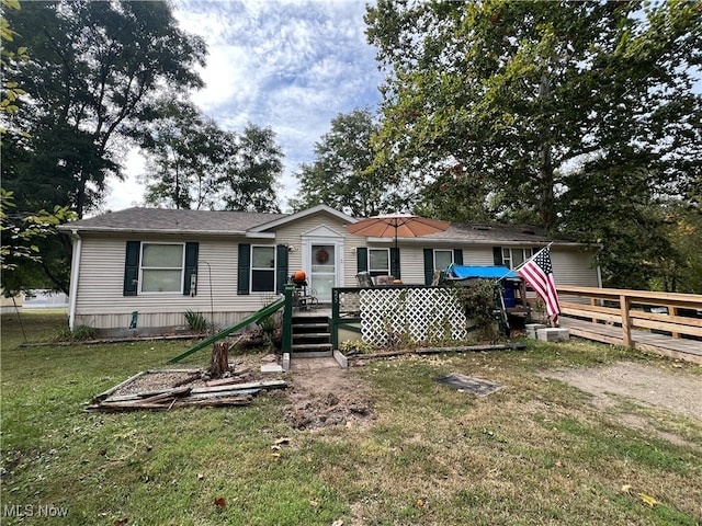 view of front of home featuring a front yard and a wooden deck