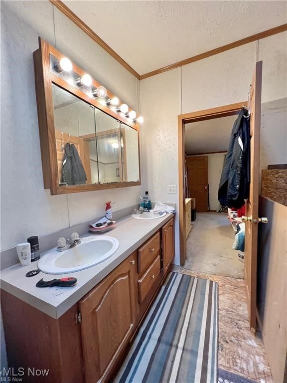 bathroom featuring vanity, ornamental molding, and a textured ceiling