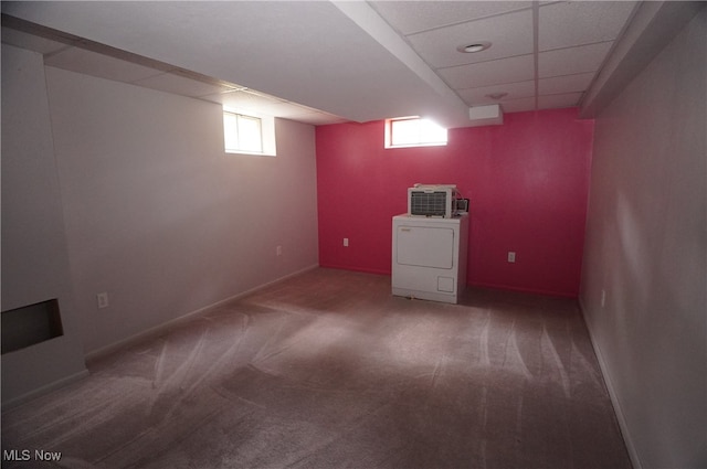 basement featuring a paneled ceiling, carpet flooring, and washer / dryer