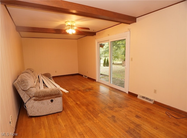 unfurnished room with wood-type flooring, beam ceiling, and ceiling fan