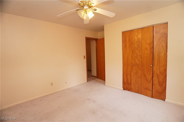 unfurnished bedroom with ceiling fan, light carpet, and a closet