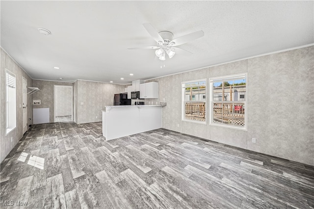 unfurnished living room with ceiling fan and hardwood / wood-style flooring