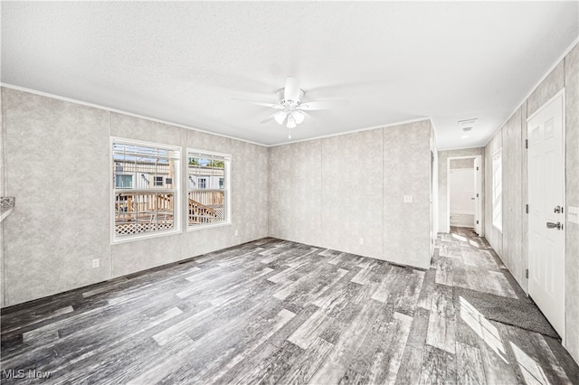 spare room featuring ornamental molding, ceiling fan, hardwood / wood-style floors, and a textured ceiling