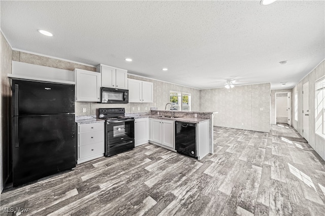 kitchen with black appliances, light hardwood / wood-style floors, sink, and white cabinets