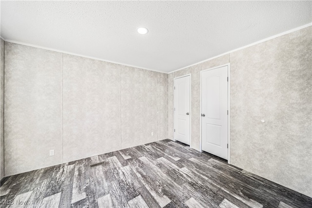 interior space featuring ornamental molding, a textured ceiling, and dark hardwood / wood-style flooring