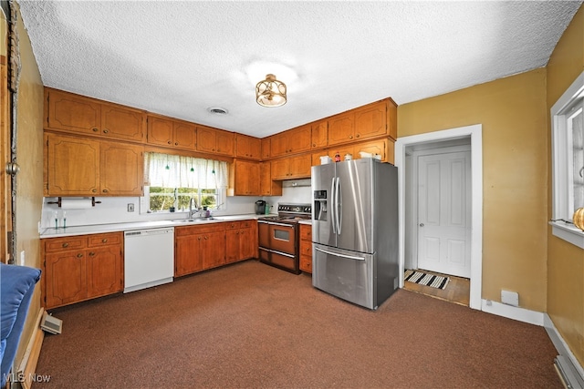 kitchen featuring dark carpet, stainless steel appliances, a textured ceiling, and sink