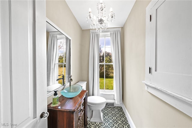 bathroom with vanity, lofted ceiling, tile patterned floors, an inviting chandelier, and toilet