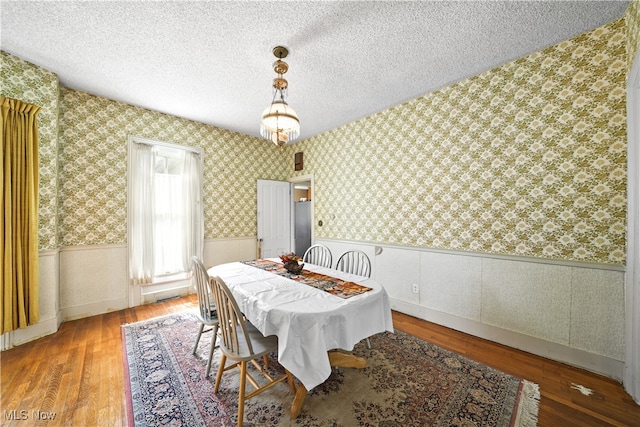 dining space featuring a textured ceiling and hardwood / wood-style floors