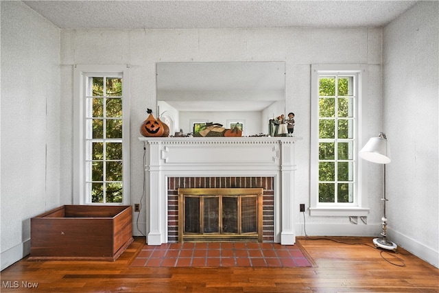 unfurnished living room with a textured ceiling, dark hardwood / wood-style floors, and a fireplace