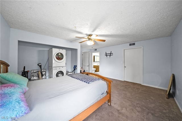 bedroom featuring a textured ceiling, carpet, ceiling fan, and stacked washer and clothes dryer