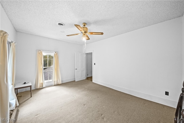 carpeted spare room with ceiling fan and a textured ceiling