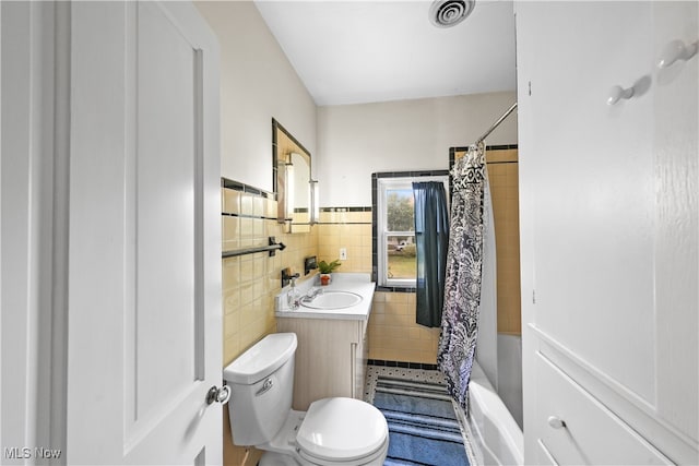 full bathroom with tile walls, vanity, toilet, and shower / bath combination with curtain