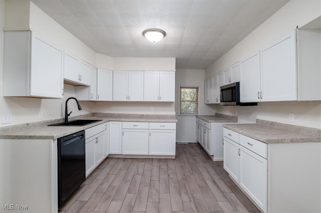 kitchen featuring light hardwood / wood-style floors, black dishwasher, sink, and white cabinets