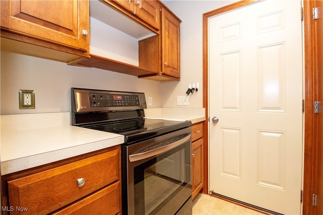 kitchen with light tile patterned flooring and electric range