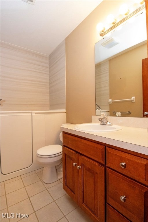 bathroom with tile patterned flooring, vanity, and toilet