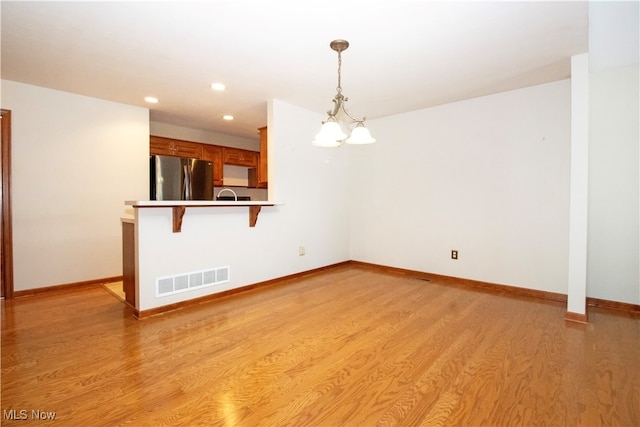 interior space featuring a notable chandelier and light hardwood / wood-style flooring