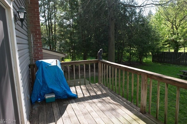 deck featuring a lawn and fence