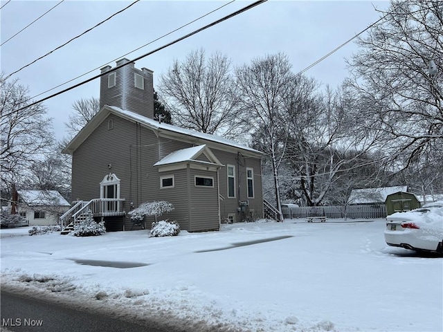 view of snowy exterior featuring a chimney