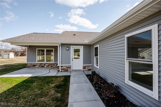 doorway to property featuring a lawn and a patio