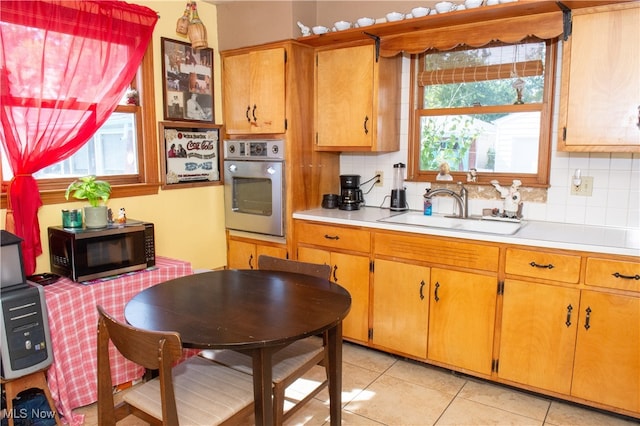 kitchen featuring decorative backsplash, stainless steel appliances, a healthy amount of sunlight, and sink