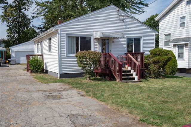 view of front facade with an outdoor structure, a garage, and a front lawn