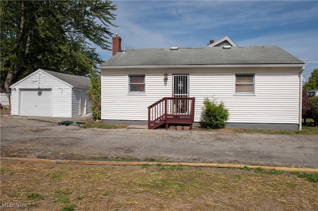 view of front of house featuring a garage and an outbuilding