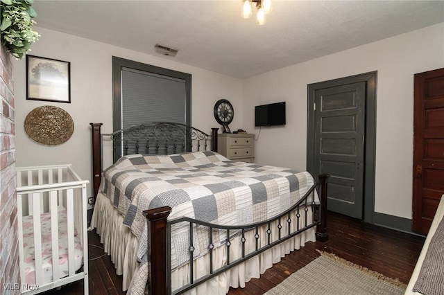 bedroom with a textured ceiling and dark hardwood / wood-style floors