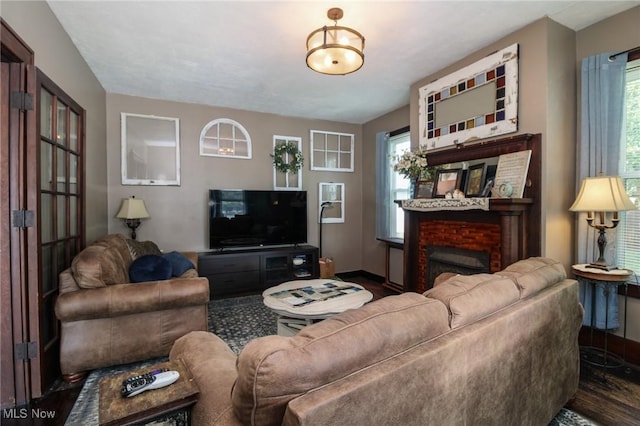 living room featuring a fireplace and dark wood-type flooring